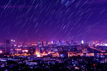 The night sky , the stars and the Tallest building in the city.