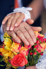 Obraz na płótnie Canvas hands of groom and bride on a wedding bouquet