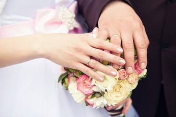 Obraz na płótnie Canvas hands of groom and bride on a wedding bouquet