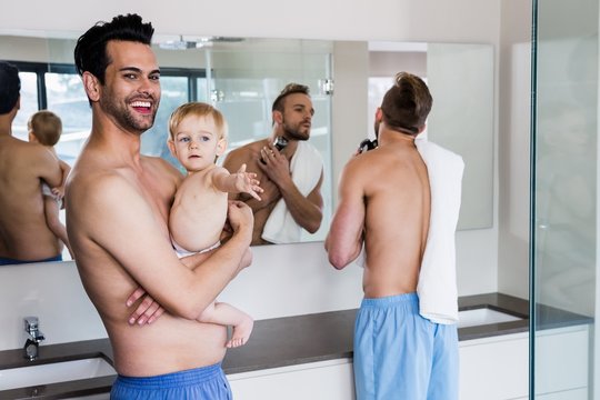 Smiling gay couple with child 