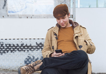 Young man sitting at city bus stop