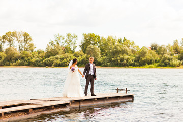 Beautiful bride and groom by a lake or river