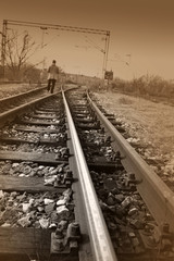 Young man walking on rail road