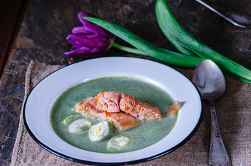 Light cream soup with spinach, red fish and quail eggs