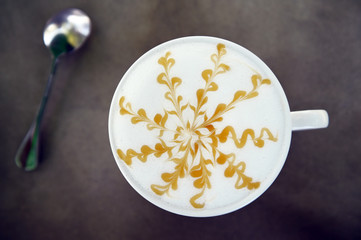 cup of latte art coffee on wooden background
