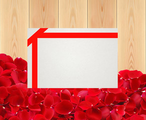 beautiful red rose petals and card on wooden planks texture