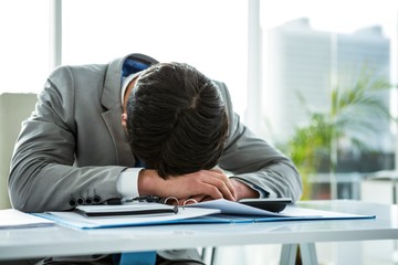 Fototapeta premium Businessman lying on his desk