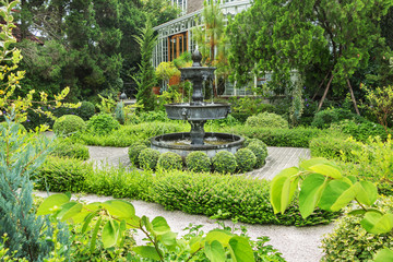 Nature background. Fountain in english garden design.