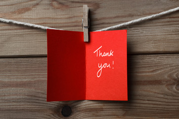 Red Thank You Card Pegged to String on Wood Background