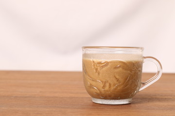 Coffee in a glass cup on a wood floor