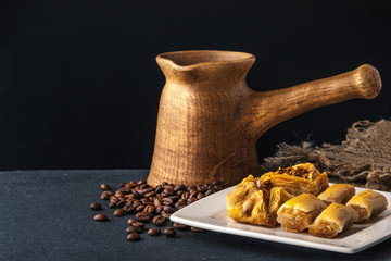 Wooden cezve with baklava on the dark table horizontal