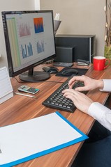 Businessman writing on keyboard in office.