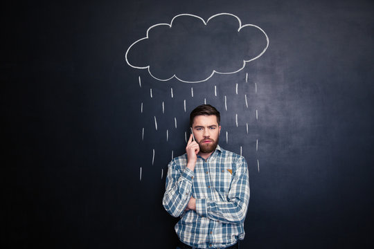 Man Talking On Mobile Phone Under Rain Drawn At Blackboard