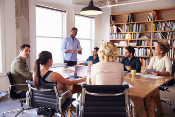 Businessman Addressing Team Meeting Around Table