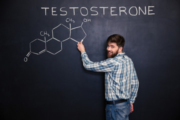 Happy man standing and drawing testosterone molecule chemical structure