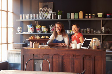 Two Female Coffee Shop Owners Standing Behind Counter