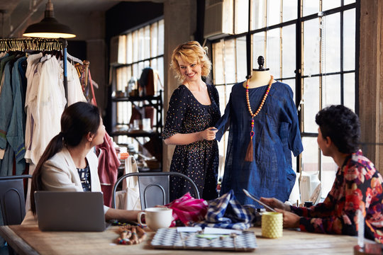 Three Fashion Designers In Meeting Discussing Garment