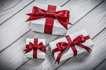 Gift boxes with red ribbons on wooden board holidays concept