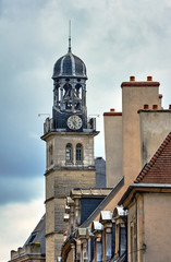 Fototapeta na wymiar Townhouses and belfry with a clock in Dijon, France.