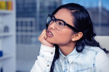 Troubled Asian woman with chin on fist