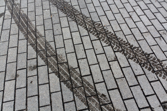 Wet tire tracks on pavement.