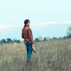 Beautiful hipster girl in a beret makes movies on vintage movie camera.