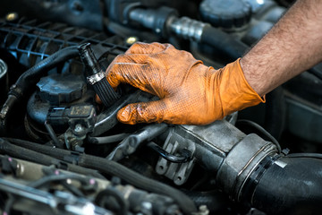 Hand of a mechanic on a car engine - obrazy, fototapety, plakaty