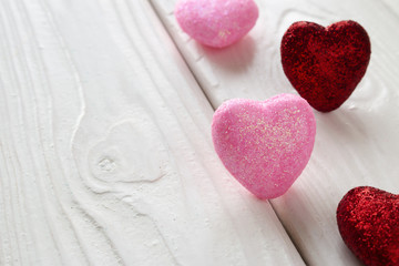 Obraz premium pink and red hearts on a white wooden background
