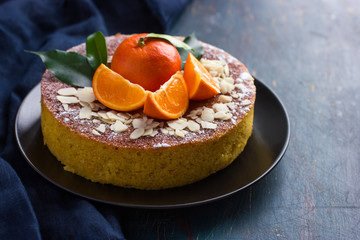 Naklejka na ściany i meble tangerine and almond cake on dark blue background,