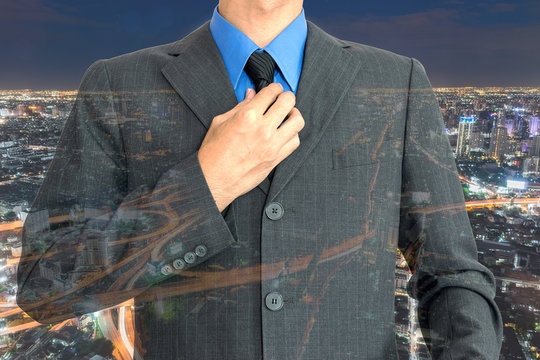 Double exposure of young businessman on night city background.