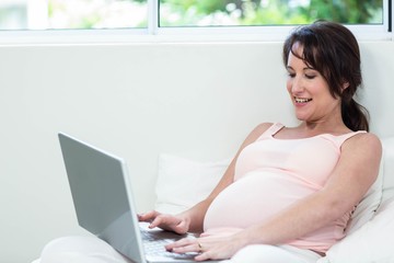 Pregnant woman relaxing with her laptop