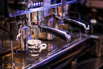 Toned photo preparing cup of coffee with coffee machine, background for coffee shop