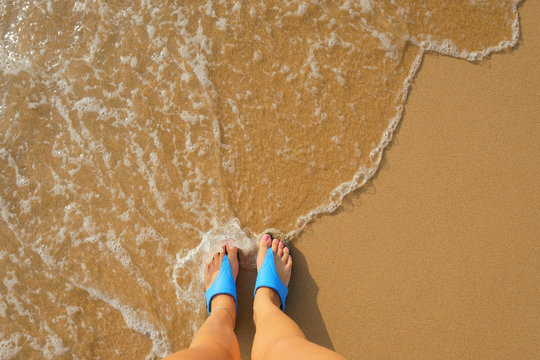 foot in flip flops on the beach