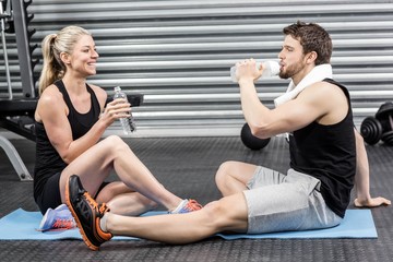 Couple sitting on fitness mat