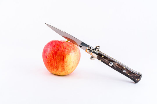 Italian switchblade knife and red apple. 