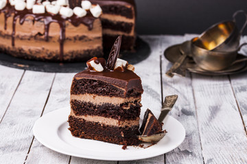 Delicious chocolate cake in white plate on wooden table background