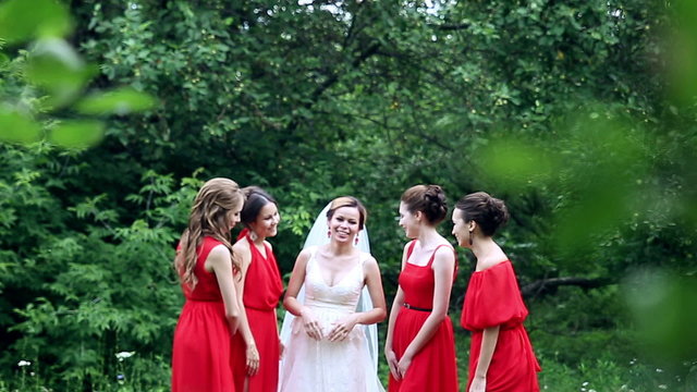Bride and bridesmaids talking and laughing, walking around. lloking at a ring, having fun. Slow motion.