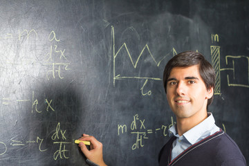 Teacher writing formulas on the blackboard