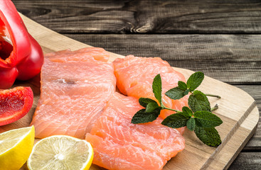 Raw salmon fillets with lemon slices, mint and pepper, selective focus.