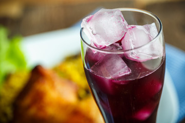 Tasty dish of chicken thigh with rice and lettuce and a glass of