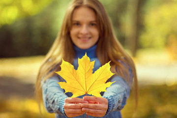 Girl shows autumn leaf