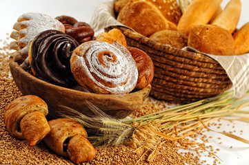 Composition with bread and rolls in wicker basket, combination of sweet pastries for bakery or...