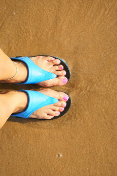 female foot in flip flops on the beach