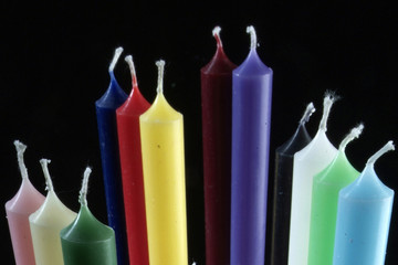 group of colorful cylindrical candles on a black background