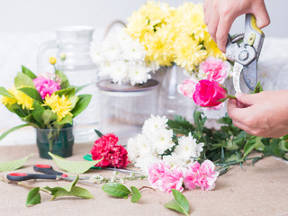 Hands of person holding flower on table of flower decoration arr