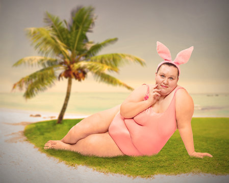 Plus size woman as a pinup girl or funny Easter Bunny on the beach. Warm filtered picture.