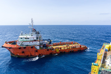 Fototapeta premium Anchor handling tug alongside a construction barge at oilfield