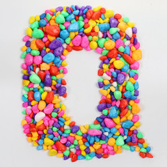 Colored stones arranged in a letter Q.