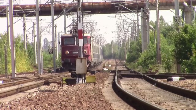 Passenger train approaching railway station under extreme heat conditions  of a hot summer day