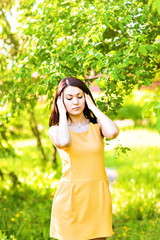 Young woman suffering with headache outdoors